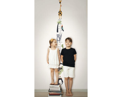 Twee kinderen staan voor een muursticker met groeimeter en dierenmotieven.