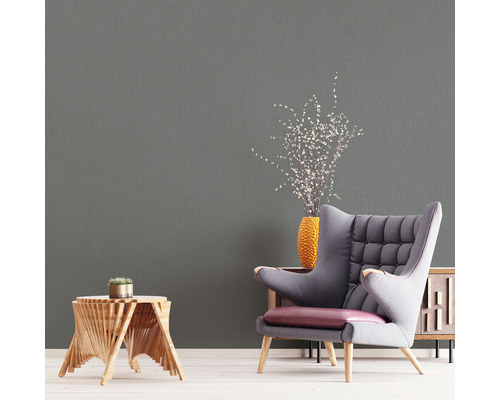 Woonkamer met grijs behang, fauteuil en bijzettafel