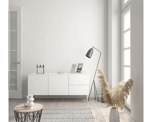 Lichte woonkamer met dressoir, staande lamp en decoratie