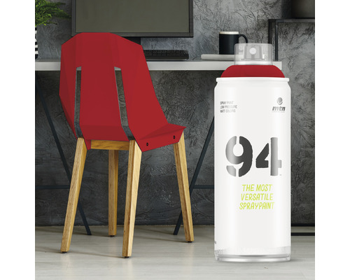 Rode stoel geverfd met spuitverf naast een spuitbus.