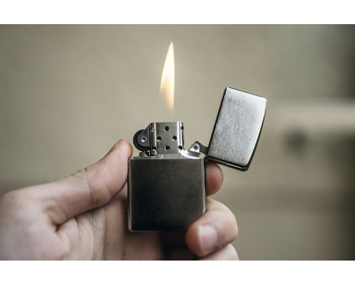 Een aansteker met open vlam in de hand