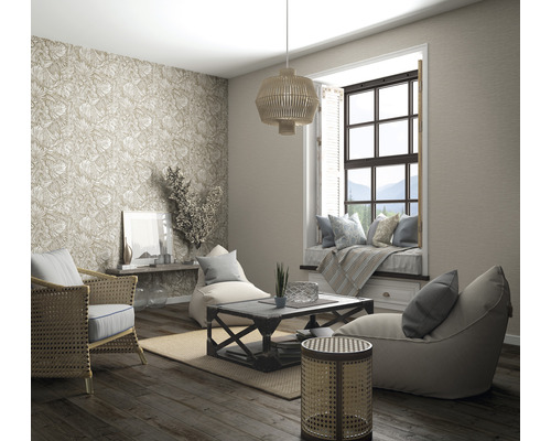 Woonkamer met rotan meubels, behang met patroon, vensterbank en houten vloer voor een lichte en georganiseerde sfeer.