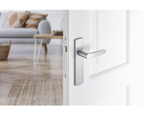 Witte binnendeur met zilverkleurige deurklink in een lichte woonkamer