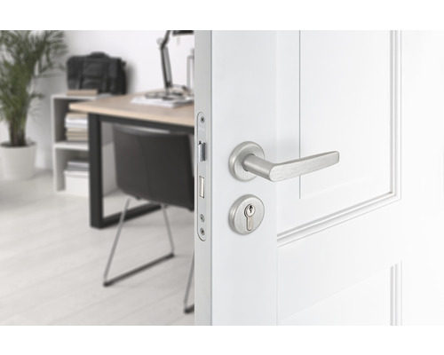 Witte deur met deurkruk en slotcilinder in een lichte werkkamer