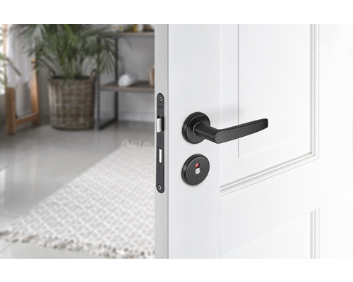 Wit gelakte deur met zwarte deurklink en slotgarnituur