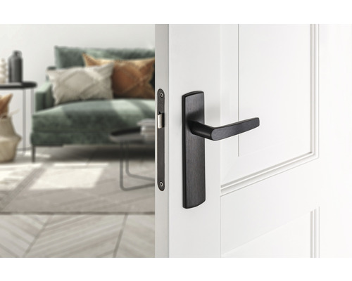 Binnendeur met zwarte deurklink in een lichte woonkamer