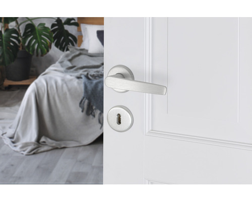 Deur met deurkruk en slotrozet in een slaapkamer