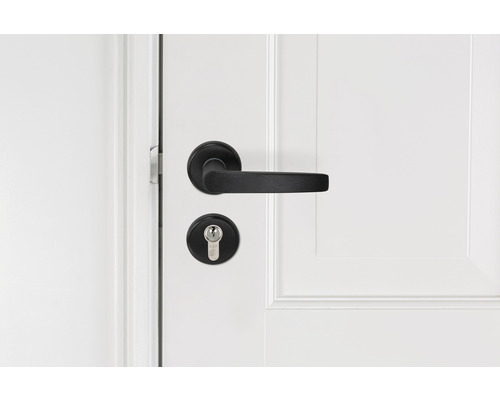 Zwart deurbeslag met sleutel op witte deur