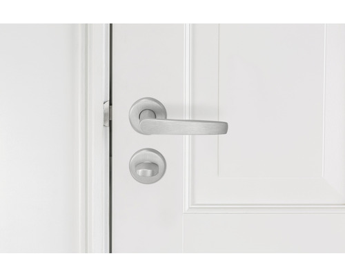 Metalen deurbeslag op een witte deur