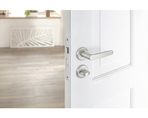 Openstaande witte binnendeur met zilverkleurige deurklink