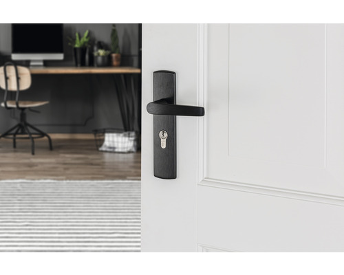 Zwarte deurklink op een witte deur in een moderne kamer