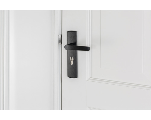 Zwarte deurklink met slot op witte deur