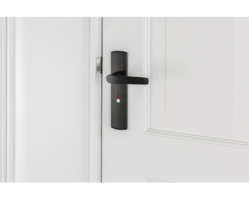 Zwarte deurklink met slot op witte deur