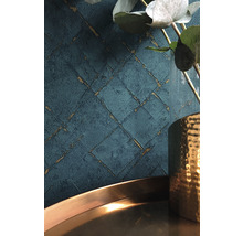 Gedetailleerde opname van een wandbehang met een geometrisch patroon en een decoratief bloemstuk in een vaas
