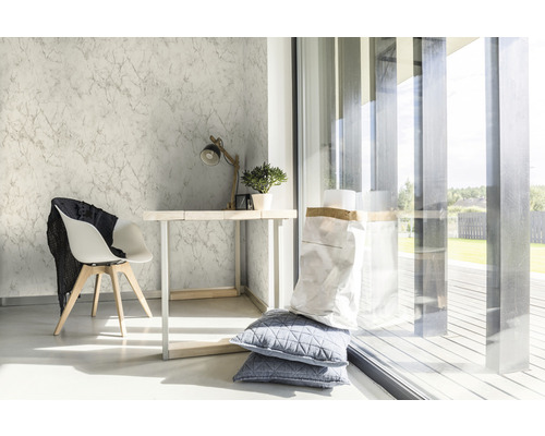 Lichte ruimte met marmeren behang, bureau, stoel en daglicht.