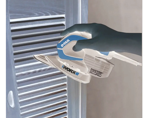 Een hand bedient een vlakschuurmachine van het merk Worx op een houten oppervlak.