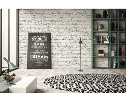 Lichte kamer met bakstenen muur, boekenkast, staande lamp, decoratie en rond vloerkleed