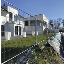 Bouwplaatsbeveiliging met bouwhek voor een modern gebouw.