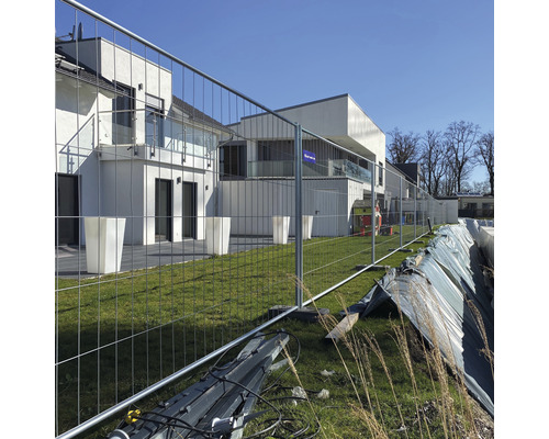 Bouwplaatsbeveiliging met bouwhek voor een modern gebouw.