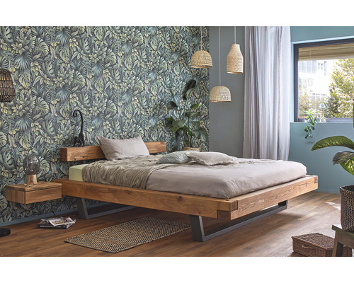 Slaapkamer met houten bed, nachtkastje en botanisch behang