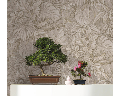 Twee bonsaibomen op een kast voor een wand met bladmotiefbehang.