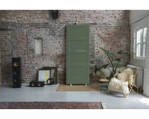 Kamerinrichting met deur, luidsprekerboxen, rotan stoel en bakstenen muur