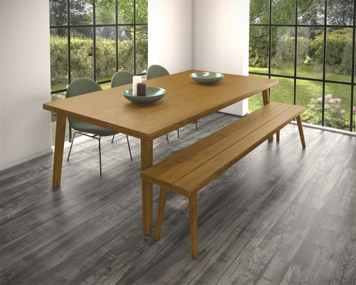 Eetkamer met houten tafel, bank en stoelen voor een raam met uitzicht op de tuin.