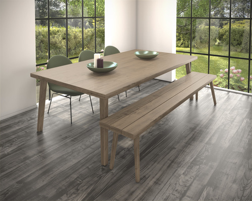 Eetkamer met houten tafel, bank en stoelen voor raam