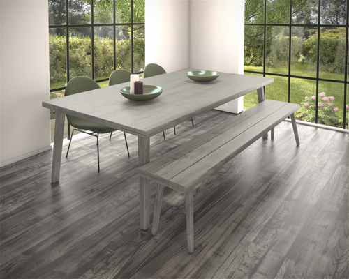 Lichte eetkamer met eettafel, bank en stoelen voor een groot raam