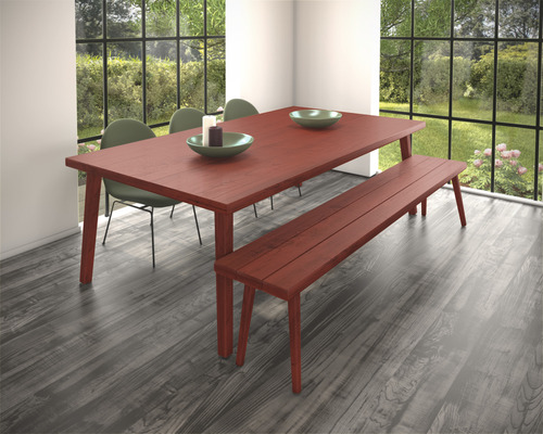 Eetkamer met houten tafel, bank en stoelen voor een raam met uitzicht op de tuin