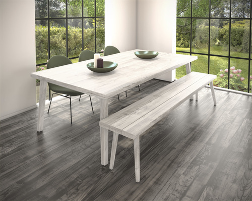 Eetkamer met eettafel, bank en stoelen voor een raam met uitzicht op de tuin.
