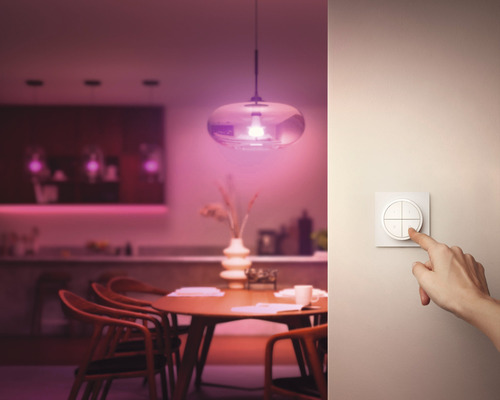 Eetkamer met eettafel, hanglamp en bedieningselement aan de muur