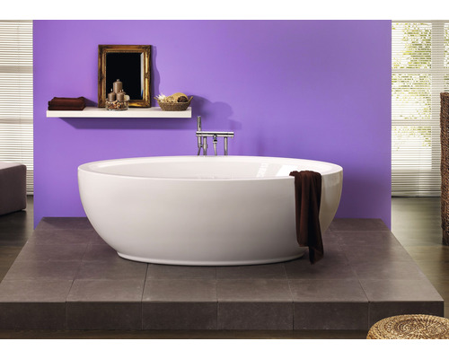 Vrijstaand bad in een badkamer met een paarse wand