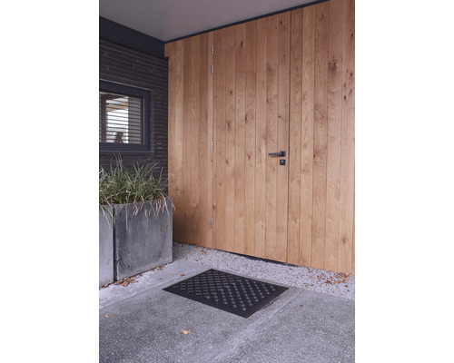 Entree met houten deur, deurmat en plantenbakken