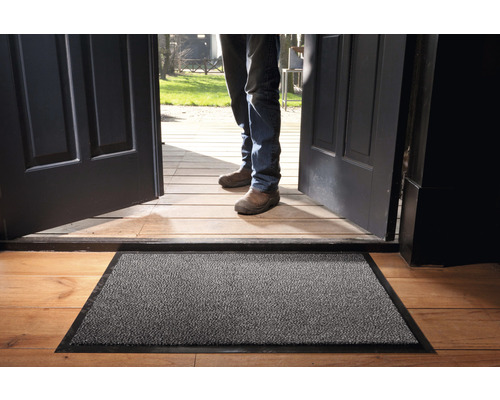 Deurmat voor een open voordeur op een houten vloer