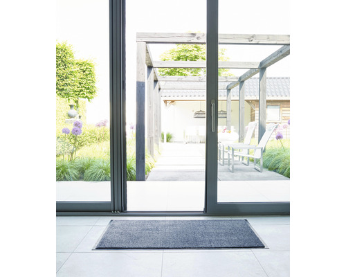 Grijze deurmat voor een terrasdeur met uitzicht op een terras