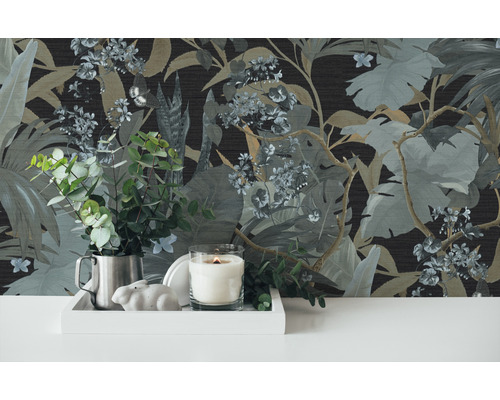Decoratieve scène met junglebehang, kaars, potplant en decoratieve elementen op een dienblad.