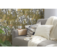 Woonkamer met grijze bank, kussens, dekens en een muur met bloemenbehang.