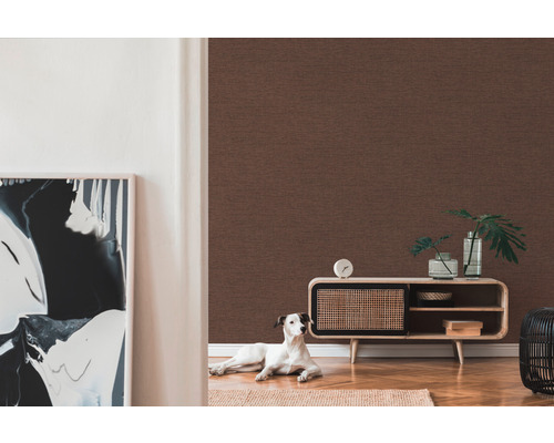 Woonkamer met bruin textielbehang, dressoir, decoratie en een hond