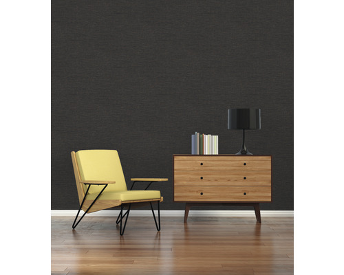 Woonkamer met zwarte muur, fauteuil en ladekast