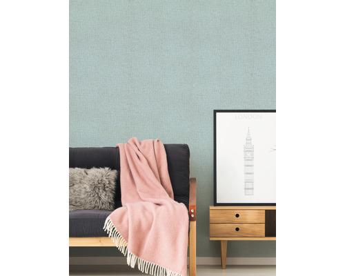 Woonkamer scène met patroonbehang, bank, kussen, deken en dressoir