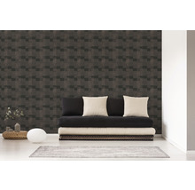 Woonkamer met een muur met geometrisch behang en een zwarte futon