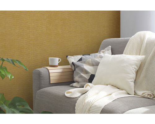 Scene met patroonbehang, bank, kussens, deken en bijzettafel