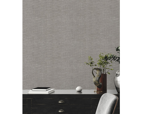 Close-up van een gestructureerd behang met een donkerhouten bureau en decoratieve objecten