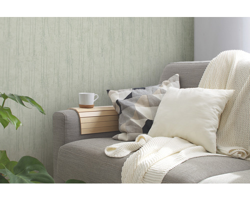 Woonkamer met patroonbehang, bank met kussens en sprei