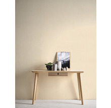 Lichte kamer met houten tafel, decoratie en fotolijst aan een muur