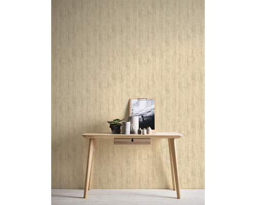 Scene met patroonbehang, bureau, plant en decoratieve objecten.