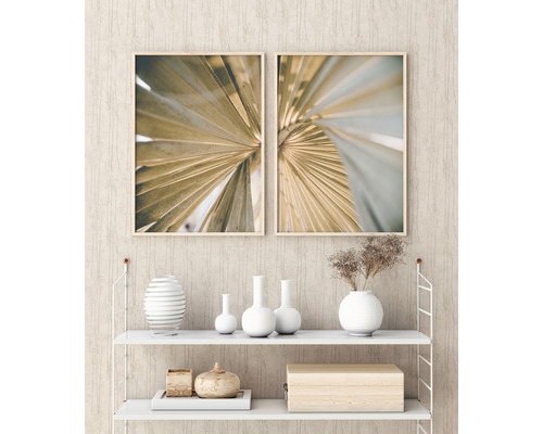 Twee ingelijste botanische prints met palmbladmotieven boven een witte plank met decoratieve objecten