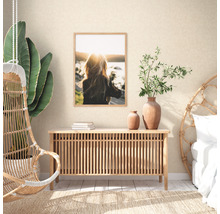 Woonkamer met dressoir, decoratie, een foto aan de muur en een hangstoel.