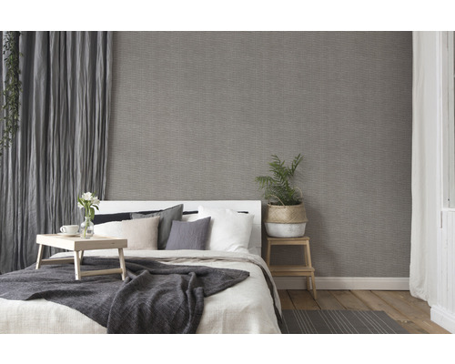 Slaapkamer met bed, nachtkastje en grijs behang